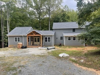 Gray ranch home with screened porch addition and new gutters around the new roofline